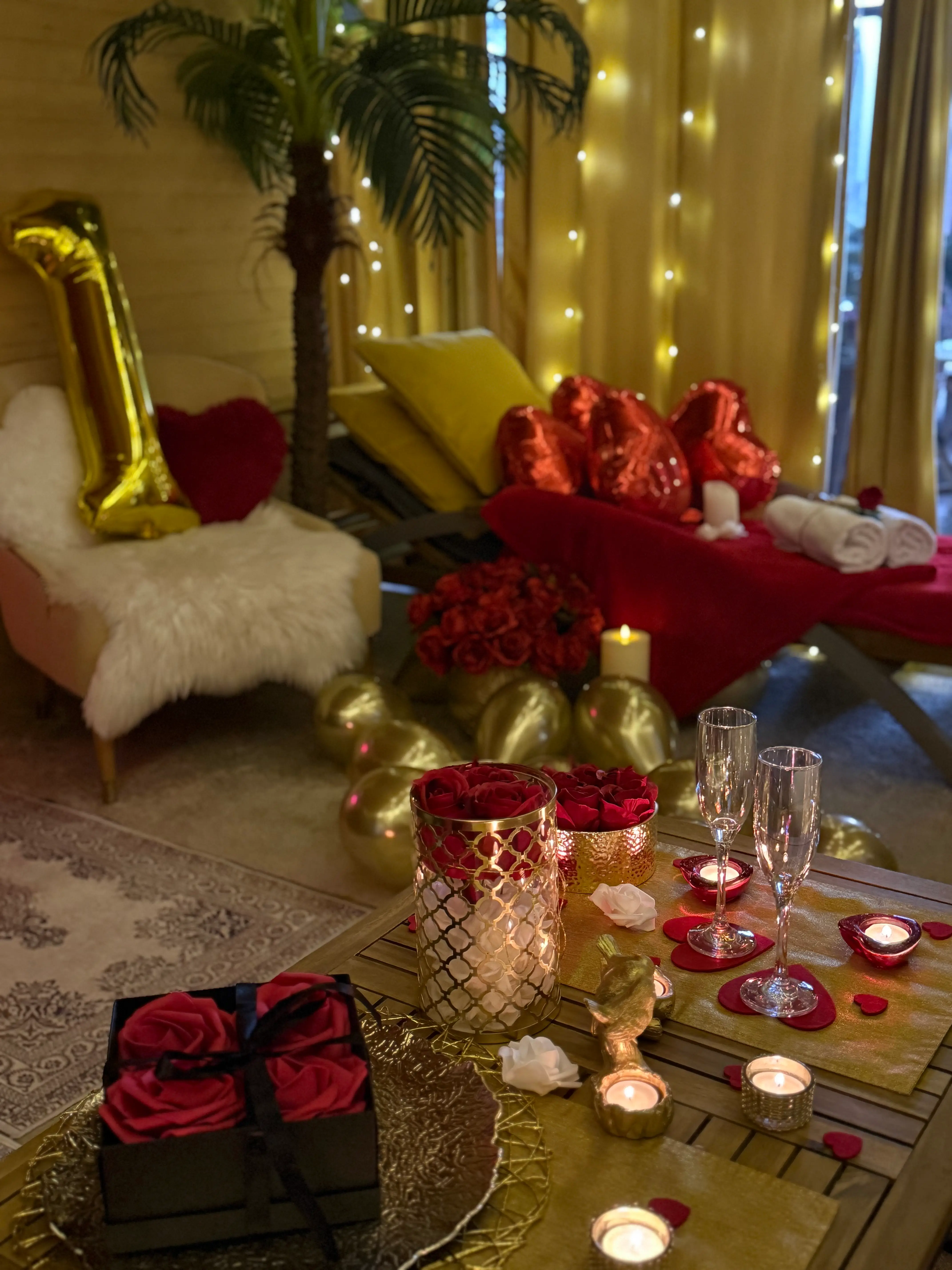 Romantic lounge scene with candles, balloons, and chaise