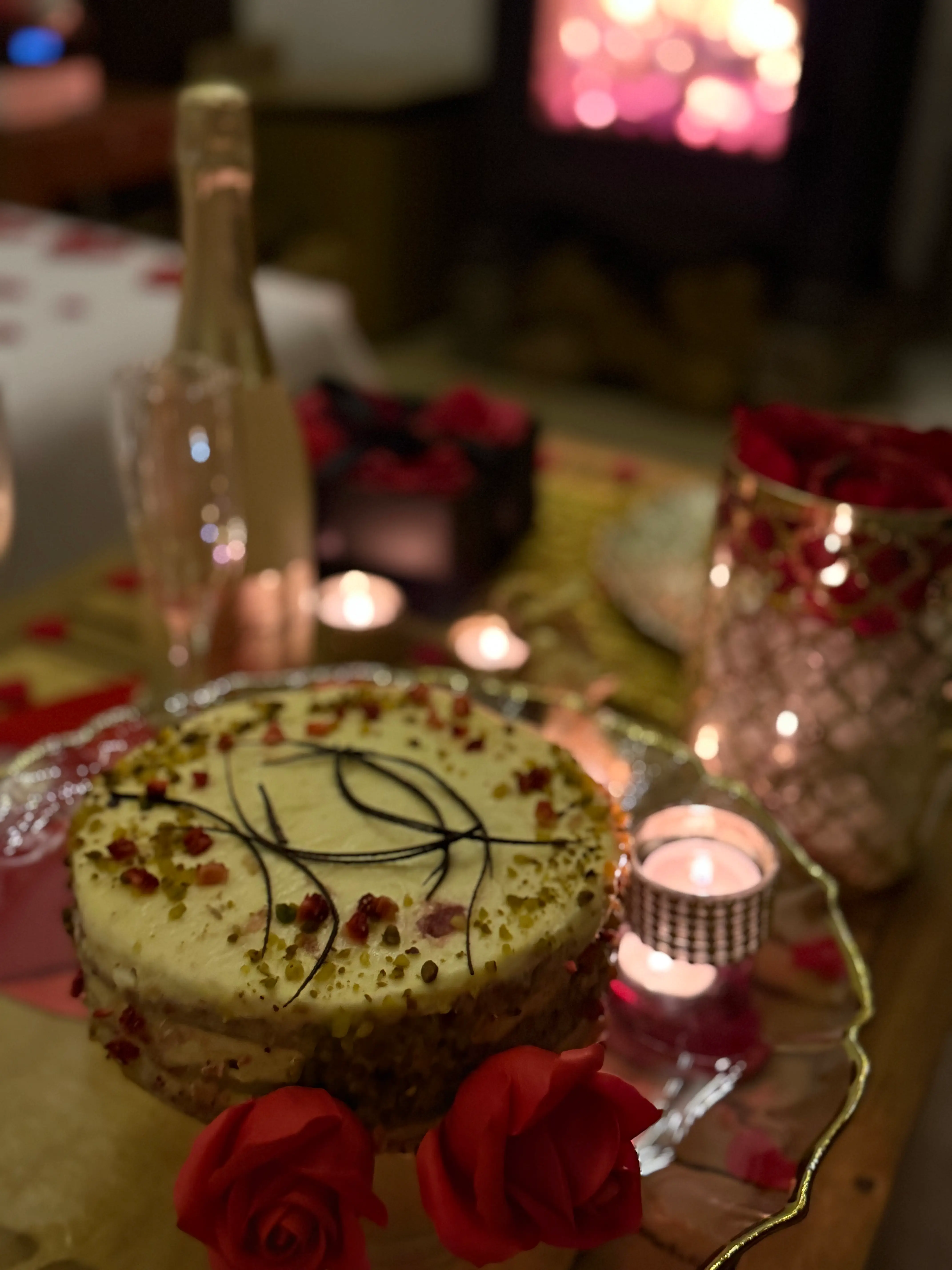 Cake on tray with candles and blurred fireplace behind
