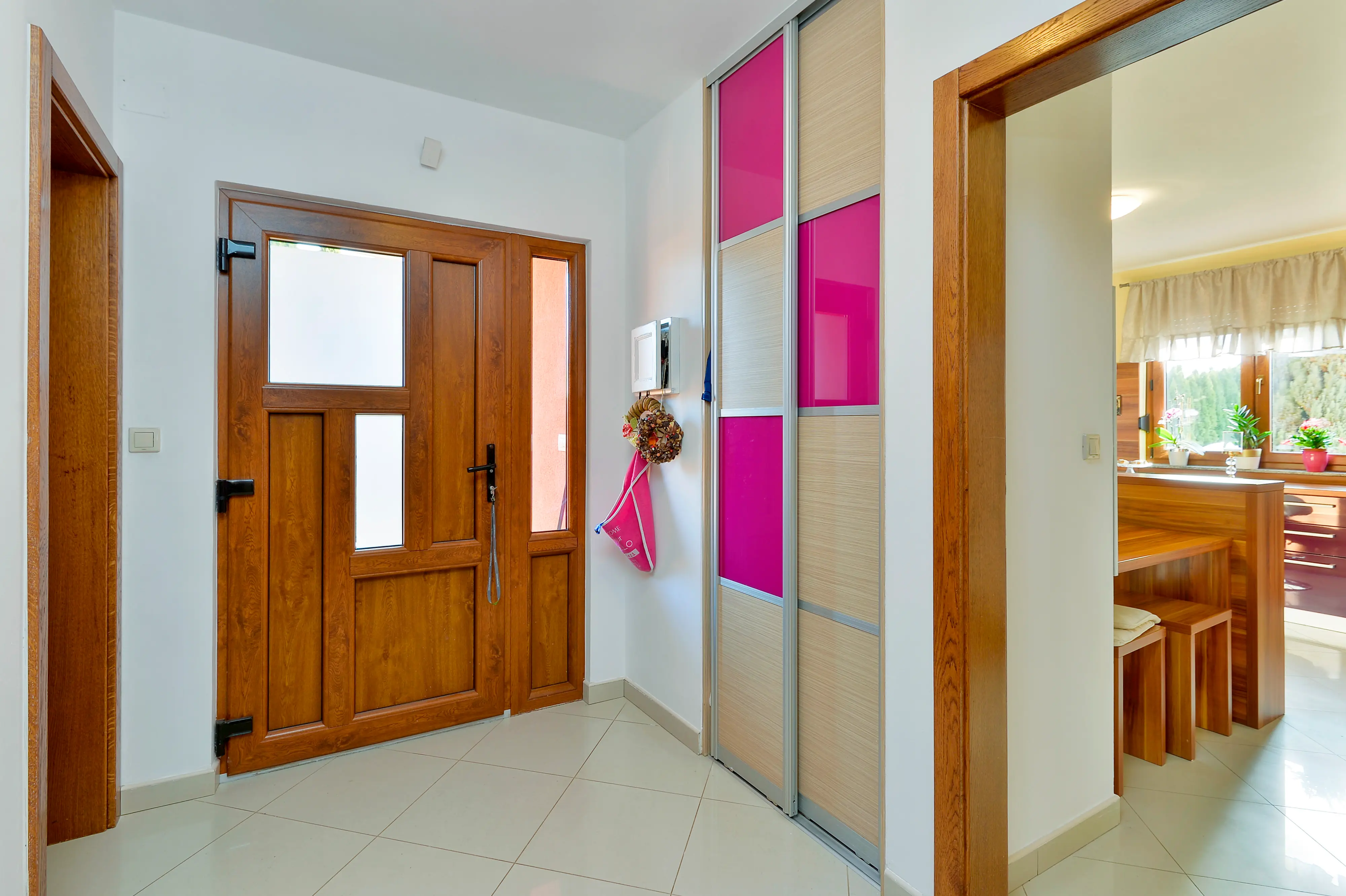 Entry hall with wooden front door and pink wardrobe