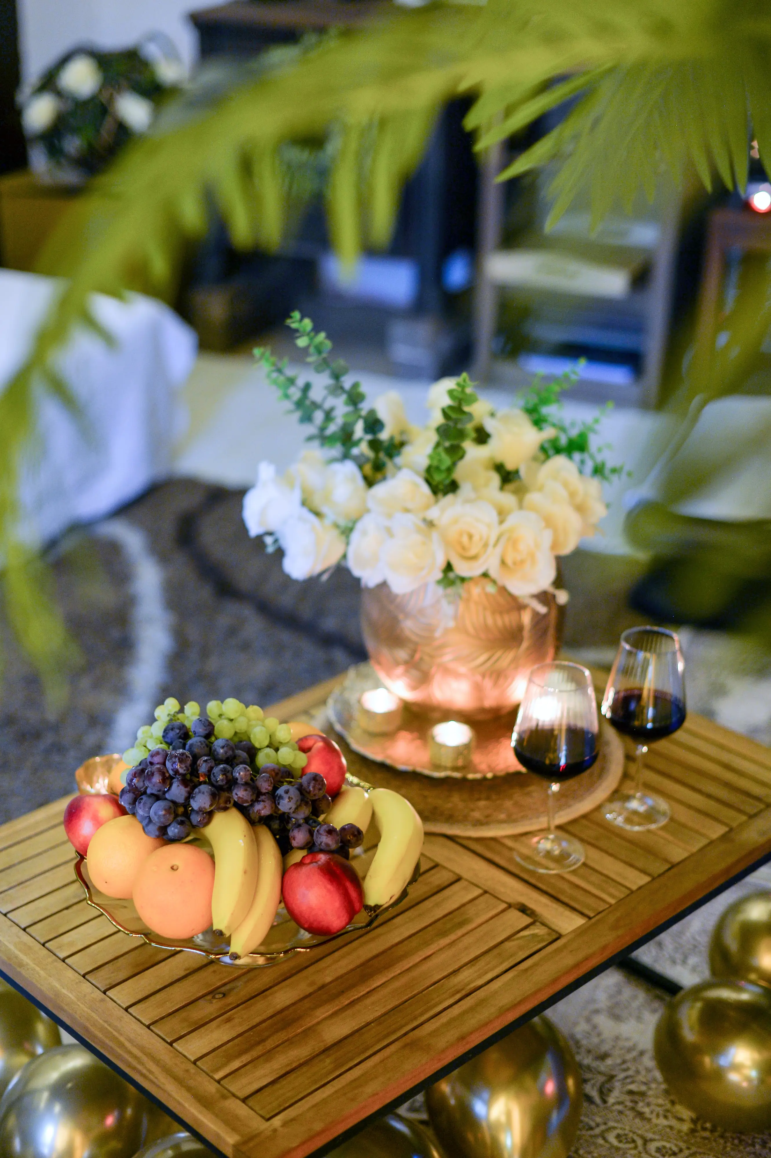 Fruit, grapes, bouquet, and wine on styled table