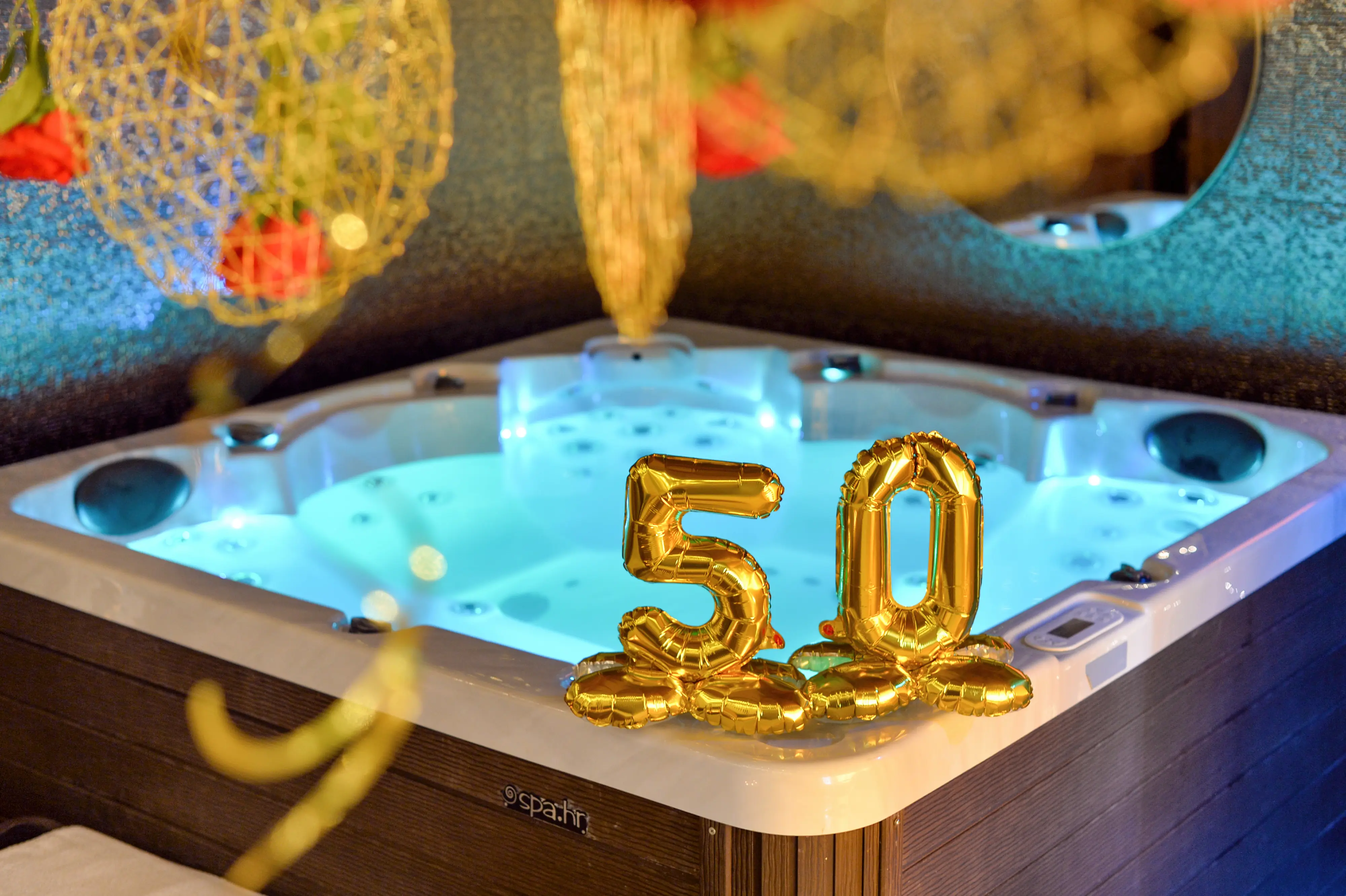 Gold 50 balloons hanging above jacuzzi corner