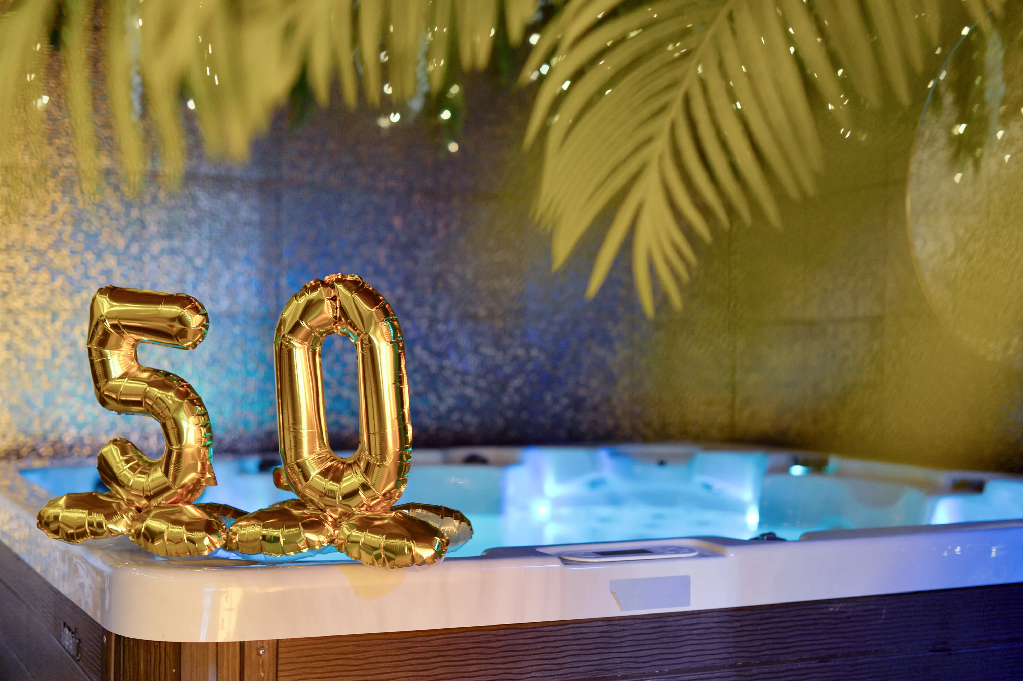 Side view of gold 50 balloons with jacuzzi behind