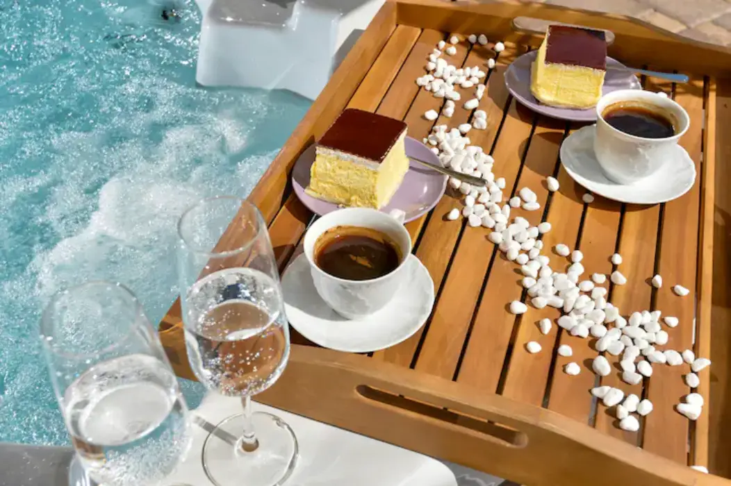 Coffee, drinks, and snacks on tray beside jacuzzi