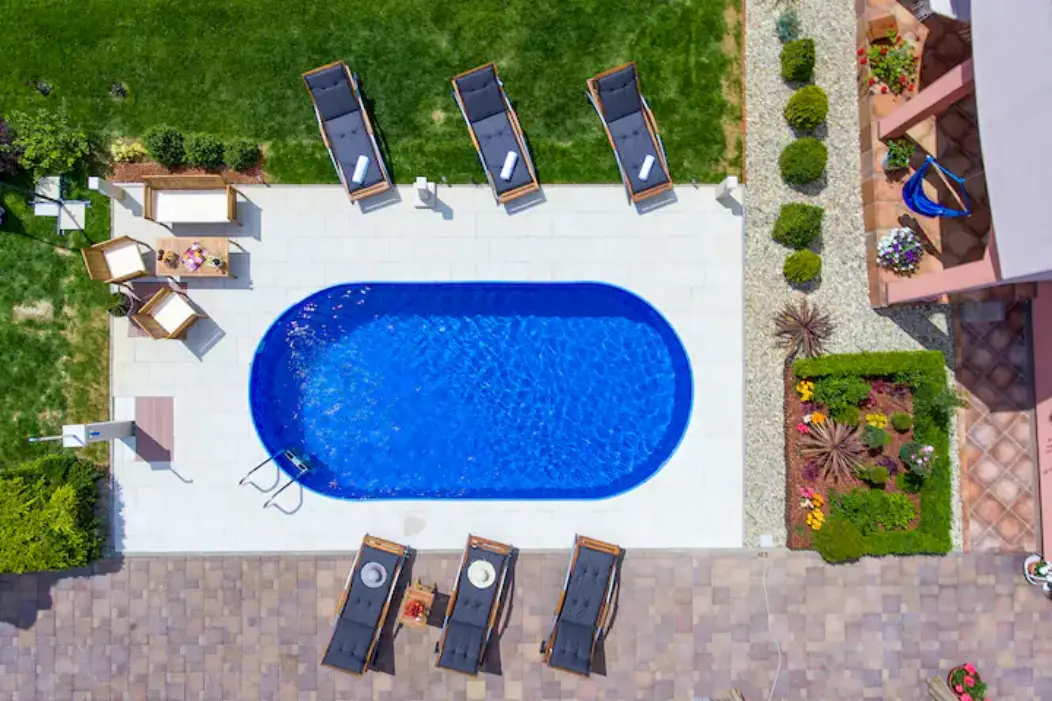 Straight-down drone shot of pool, loungers, and patio
