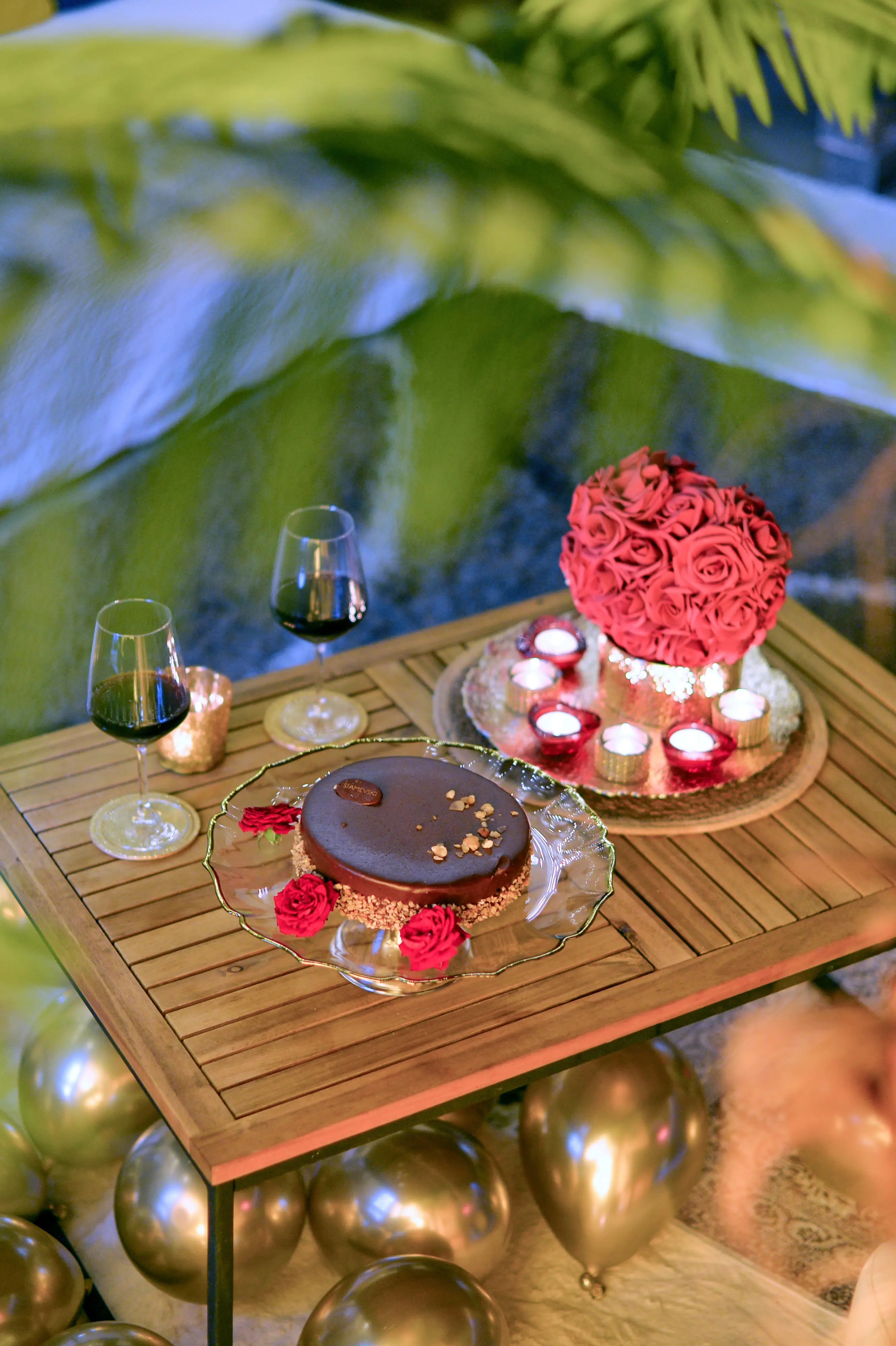Tighter dessert-table close-up through foreground leaves