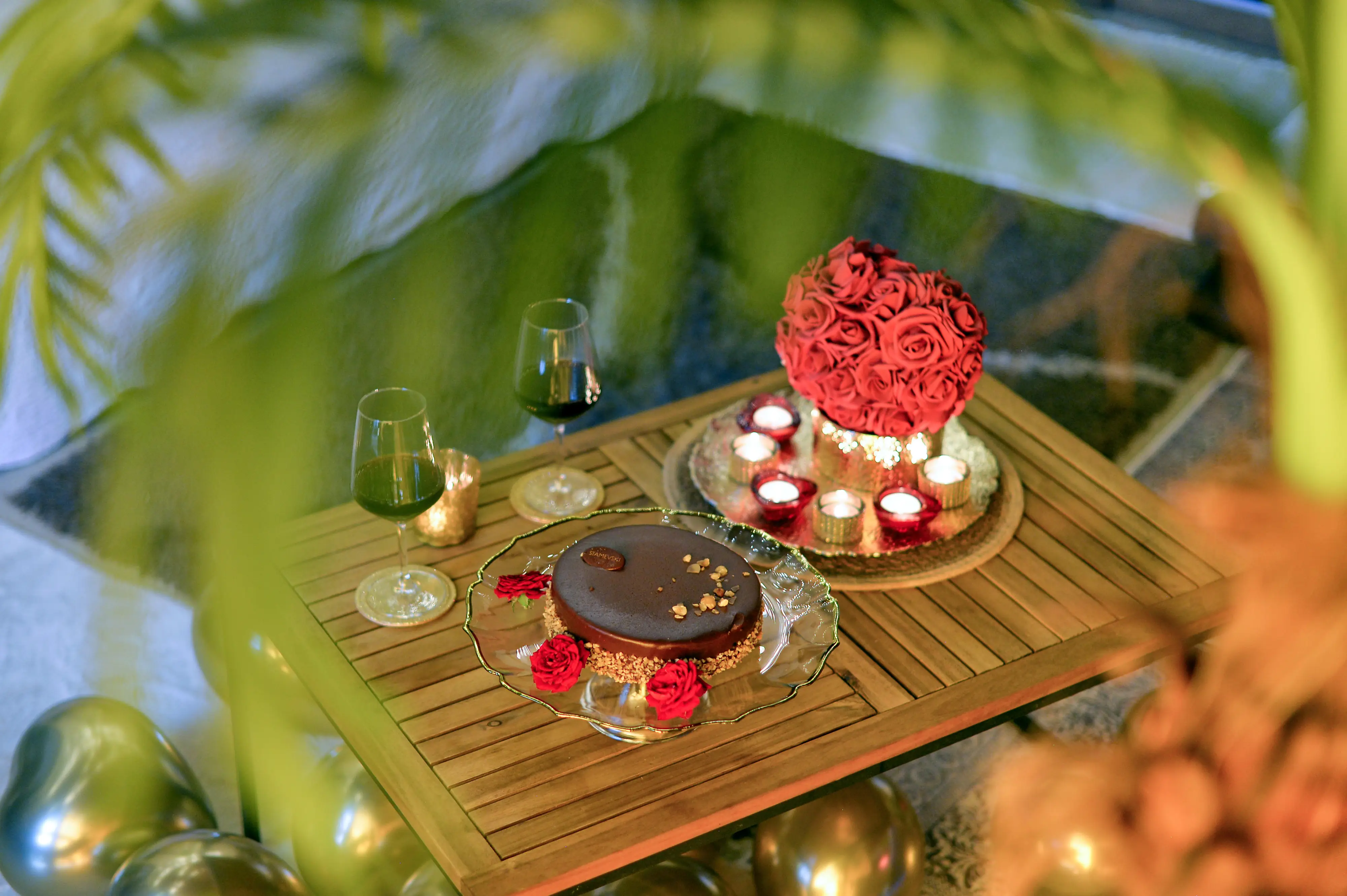 Romantic table with chocolate dessert, wine, petals, and candles