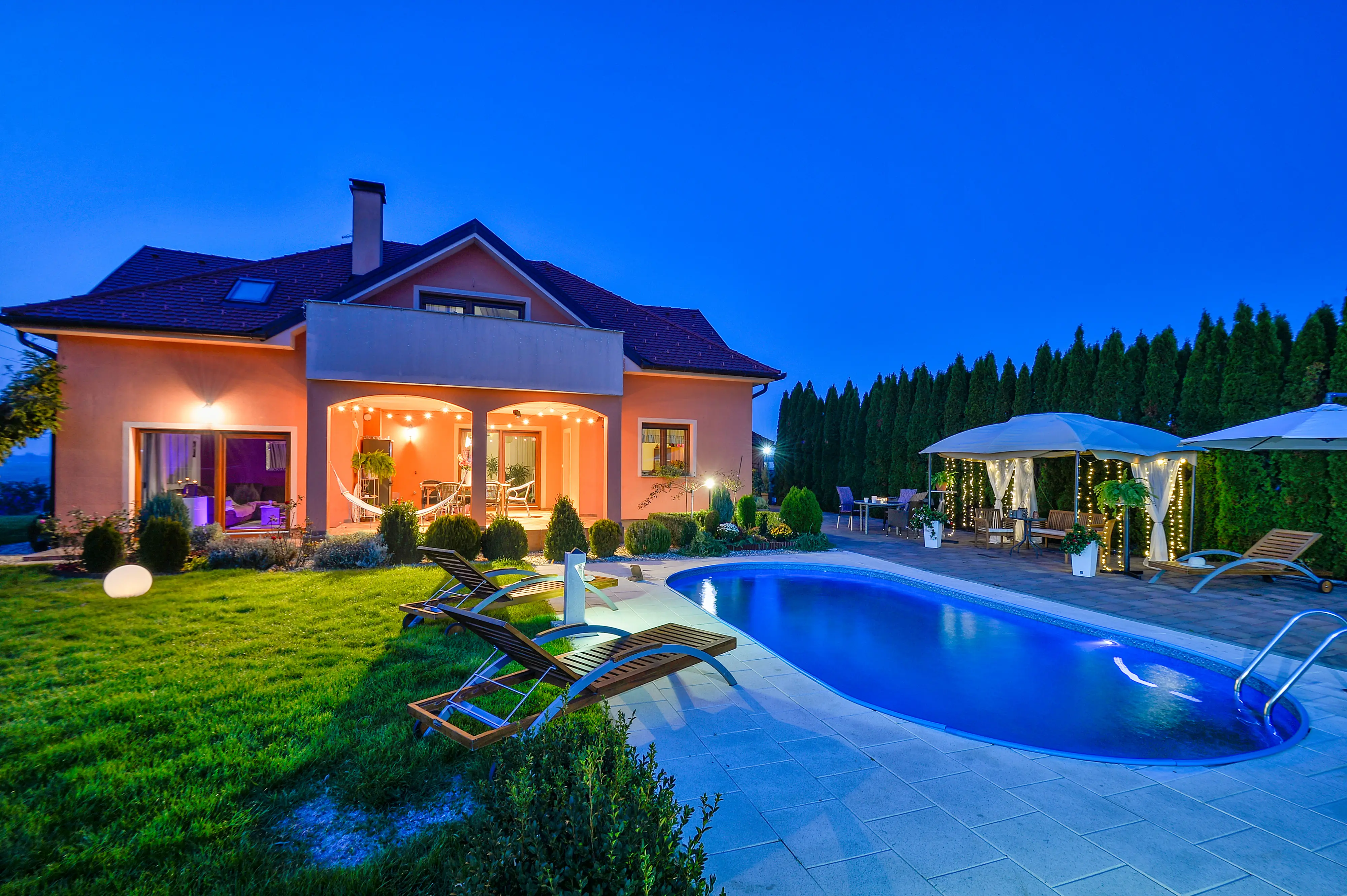 Twilight exterior with pool and patio from similar angle