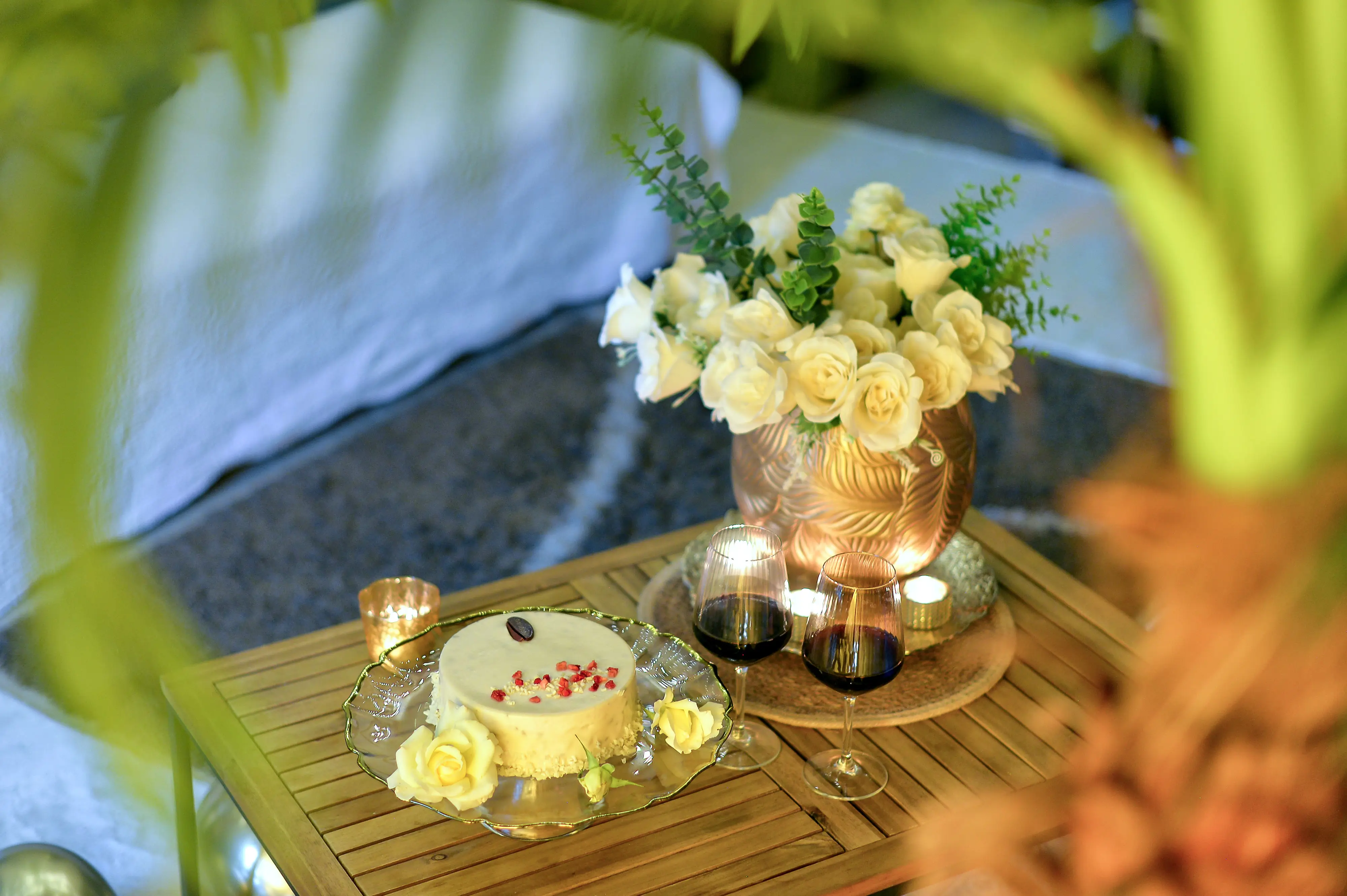White rose bouquet with candles on soft-focus table