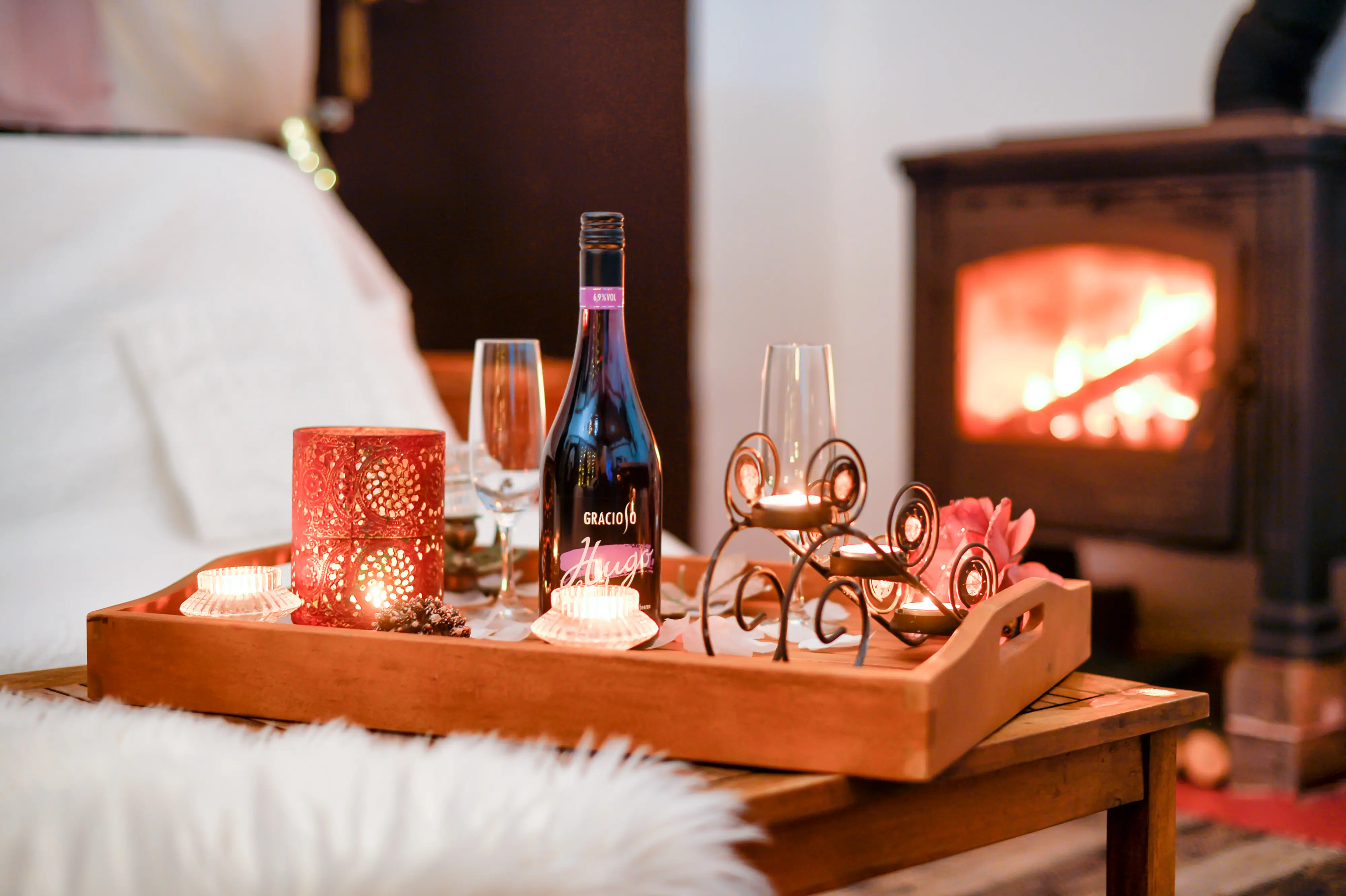 Wine tray and candles with fireplace bokeh